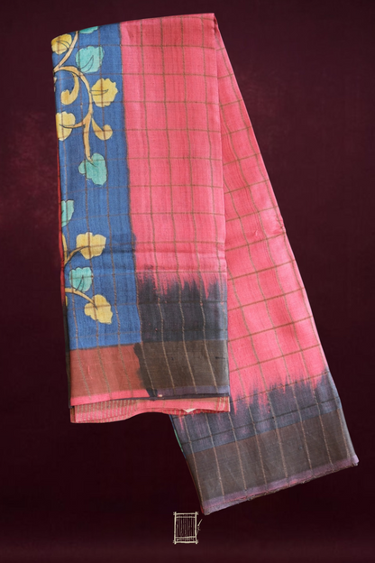 Coral pink and indigo hand-painted kalamkari tussar saree flatlay with shibori-edge border