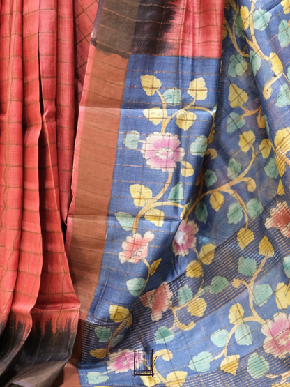 Pleats and pallu shot — coral check pleats falling beside indigo kalamkari floral pallu
