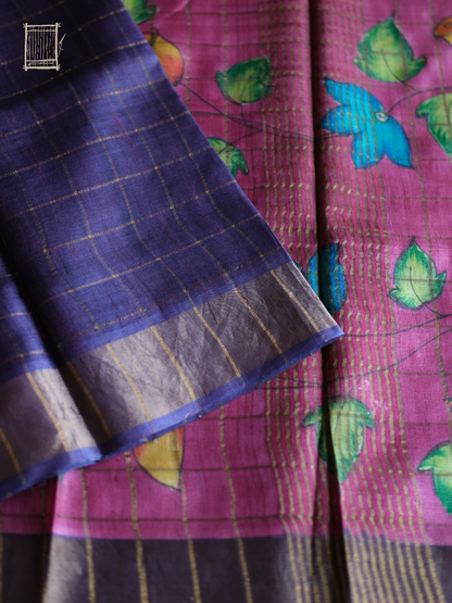 Magenta kalamkari pallu with blue lotus and mustard buds beside dusty violet tussar body
