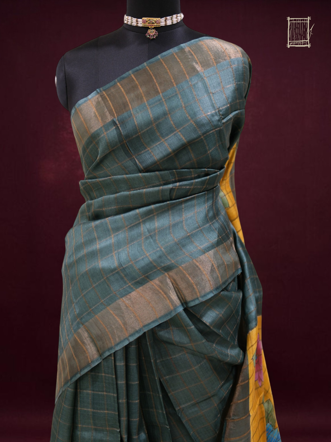Half-body drape detail of sea-teal tussar saree showing zari check pleats and pallu